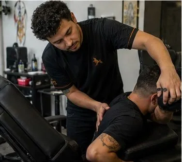 tattoo artist adjusting a client's position